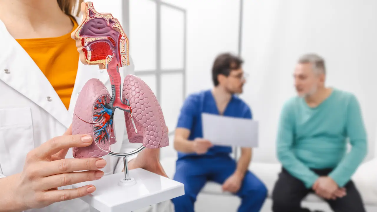 Pulmonologist explaining lung health to an adult patient, highlighting differences between asbestosis and mesothelioma.